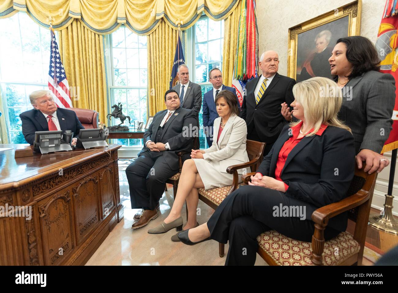 U.S President Donald Trump, joined by Cabinet members talks with workers during the “Cutting the Red Tape and Unleashing Economic Freedom” event in the Oval Office of the White House October 17, 2018 in Washington, DC. Stock Photo