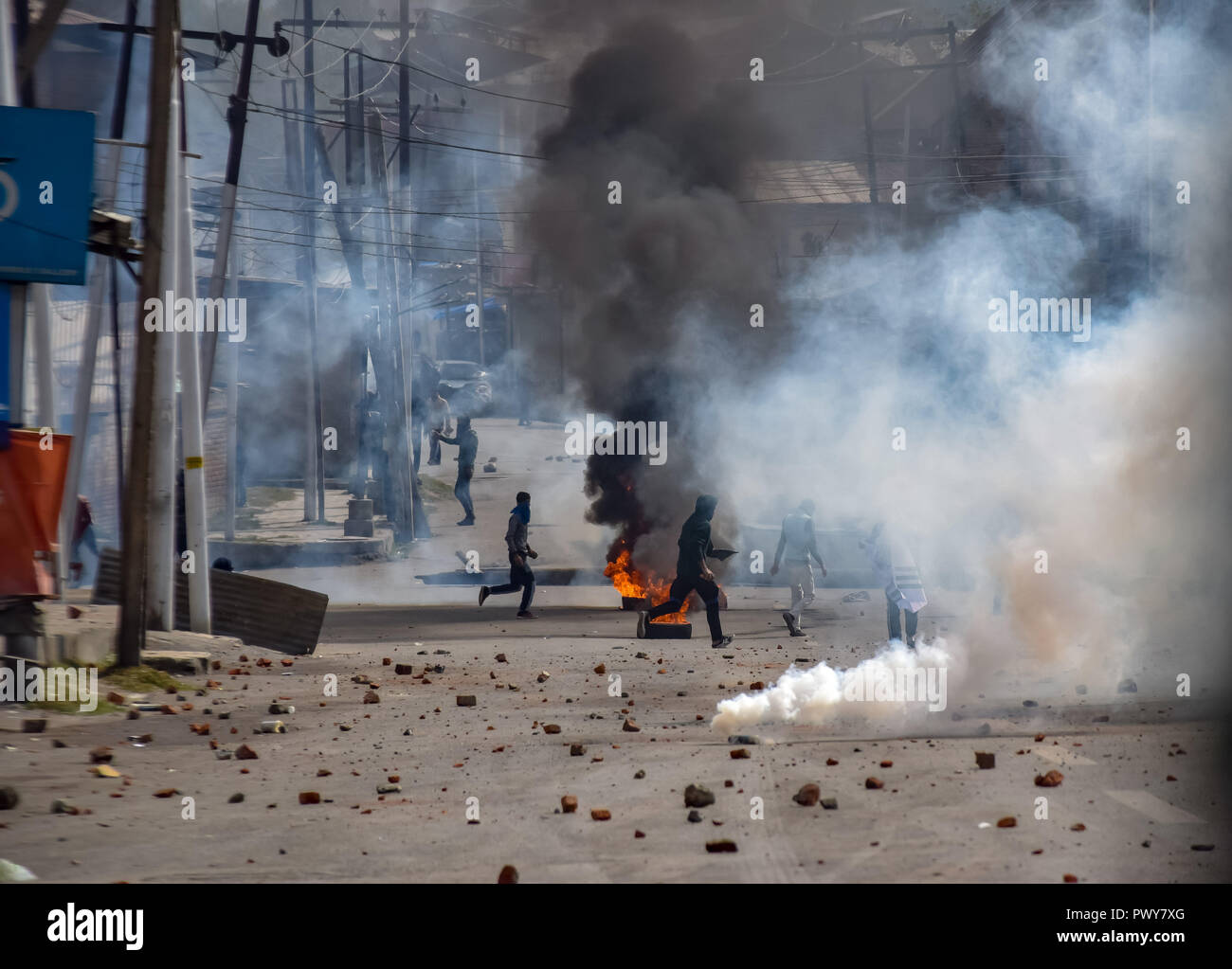 October 17, 2018 - Srinagar, Jammu & Kashmir, India - Kashmiri protesters are seen running for cover as police officers fire pellets and tear smoke cannisters towards them during clashes. Credit: Idrees Abbas/SOPA Images/ZUMA Wire/Alamy Live News Stock Photo