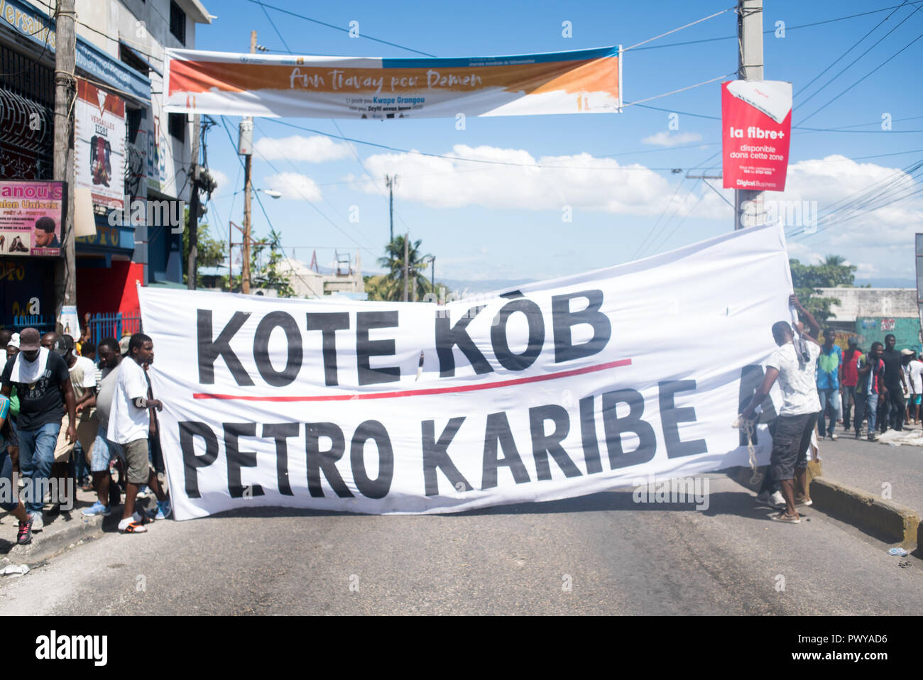 October 17, 2018 - Port-Au-Prince, Ouest, Haiti - Protesters seen holding a banner as they gathered to demonstrate against the $3.8 billion that the government and private firms have been accused of embezzling from Venezuela's subsidized PetroCaribe oil program. The revenue was supposed to go toward financing economic and social programs. The PetroCaribe Challenge was started after Haitian filmmaker Gilbert Mirambeau Jr. posted on social media asking: 'Kot KÃ²b PetroCaribe a,'' or 'Where did the PetroCaribe money go?'' With a large youth, grassroots base nationwide demonstrations acros Stock Photo