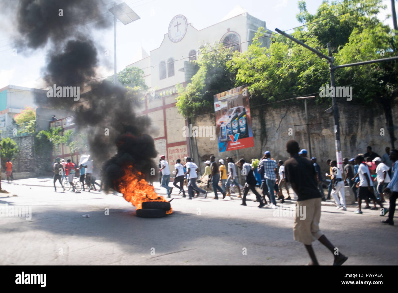 October 17, 2018 - Port-Au-Prince, Ouest, Haiti - Burning tires in the streets as tens of thousands of protesters march down the streets. Protesters gathered to demonstrate against the $3.8 billion that the government and private firms have been accused of embezzling from Venezuela's subsidized PetroCaribe oil program. The revenue was supposed to go toward financing economic and social programs. The PetroCaribe Challenge was started after Haitian filmmaker Gilbert Mirambeau Jr. posted on social media asking: 'Kot KÃ²b PetroCaribe a,'' or 'Where did the PetroCaribe money go?'' With a la Stock Photo