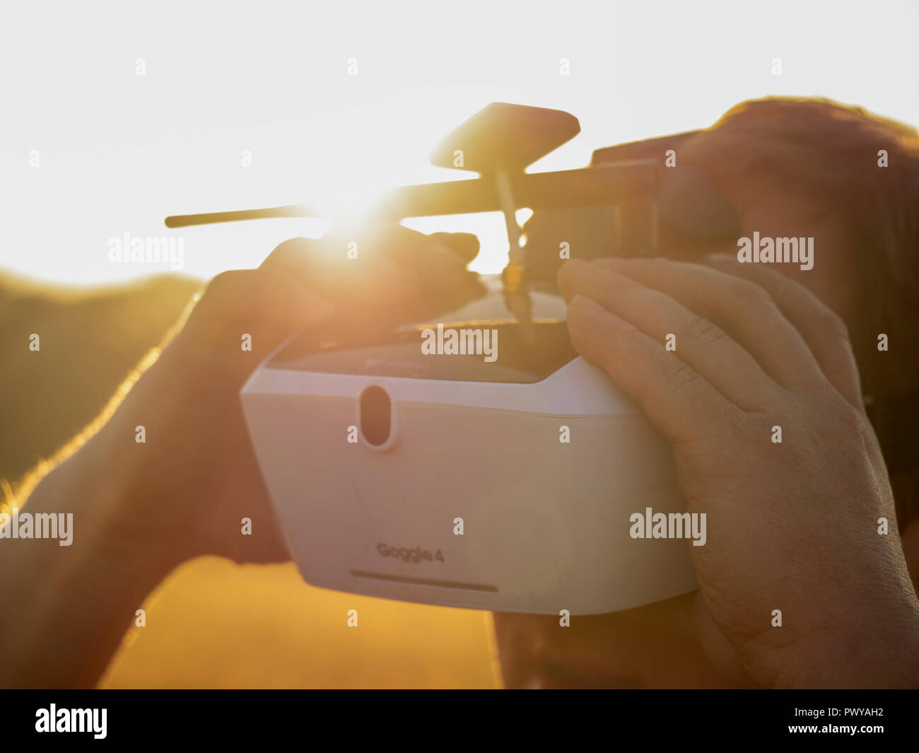 Drone pilot seen wearing a first-person view headset. Young man driving a quad-copter using video-goggles Stock Photo