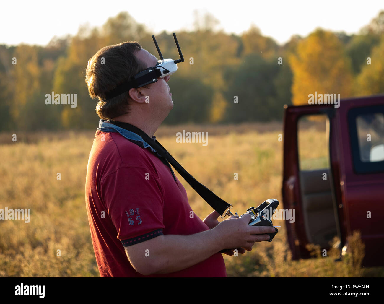 Drone pilot seen wearing a first-person view headset. Young man driving a quad-copter using video-goggles Stock Photo