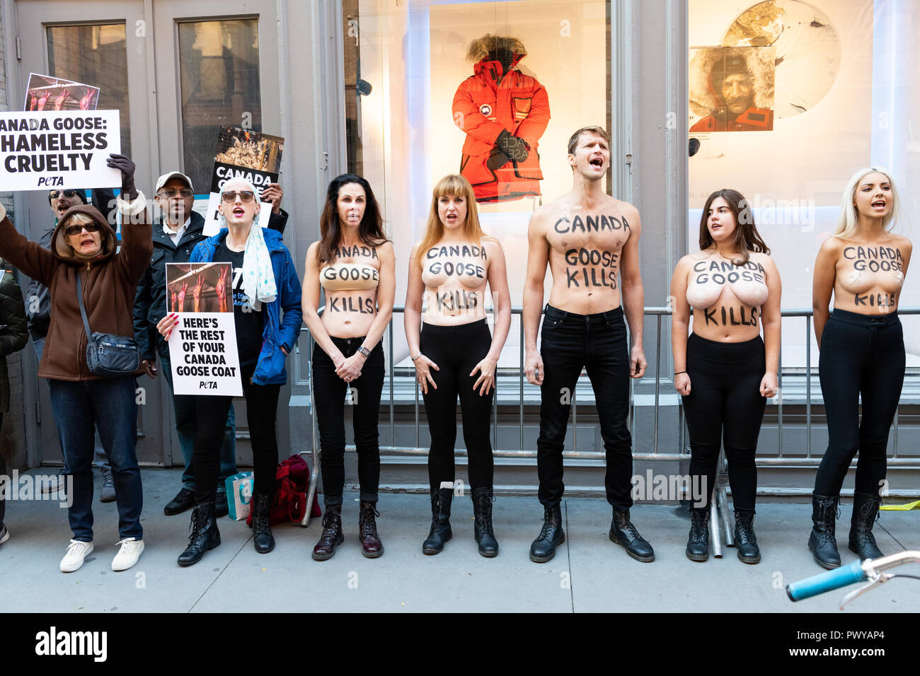 Protesters are seen standing with writings on their bodies while others ...