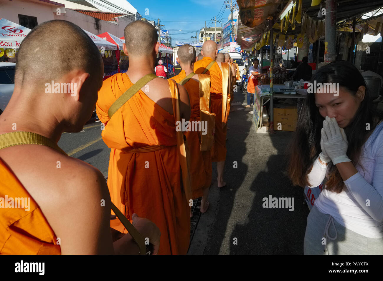 Monks living by the Big Buddha in Phuket, Thailand, on a morning alms round in Ranong Rd., Phuket Town, which they perform on the weekly 'Buddha Days' Stock Photo