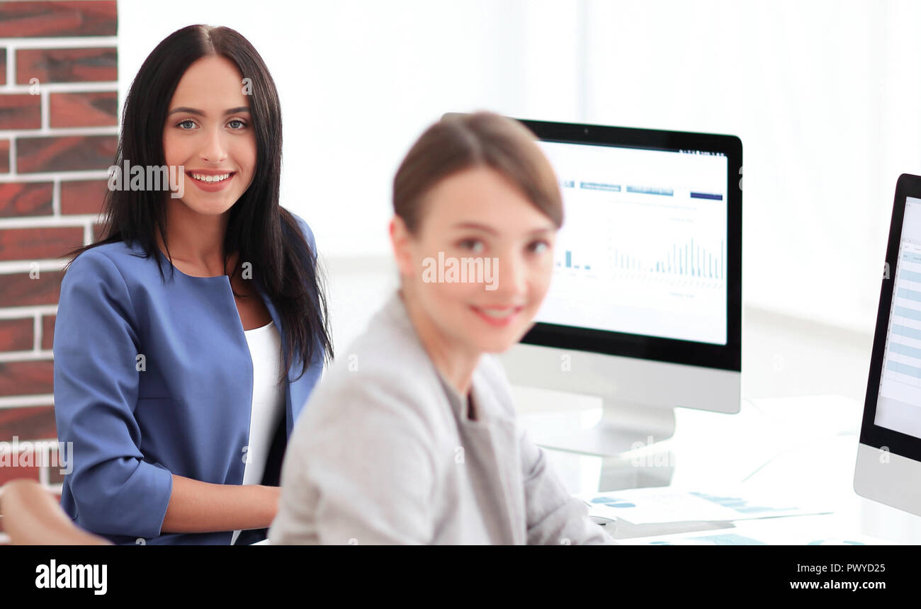 Two young business woman working together in office space Stock Photo ...