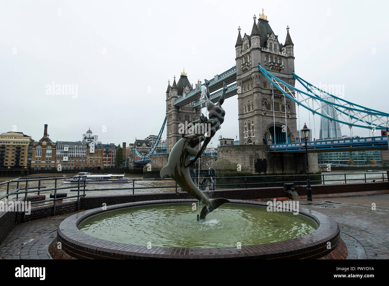 Tower Bridge Crossing the River Thames with Butlers Wharf from the Girl with a Dolphin Fountain on the North Bank London England United Kingdom Stock Photo