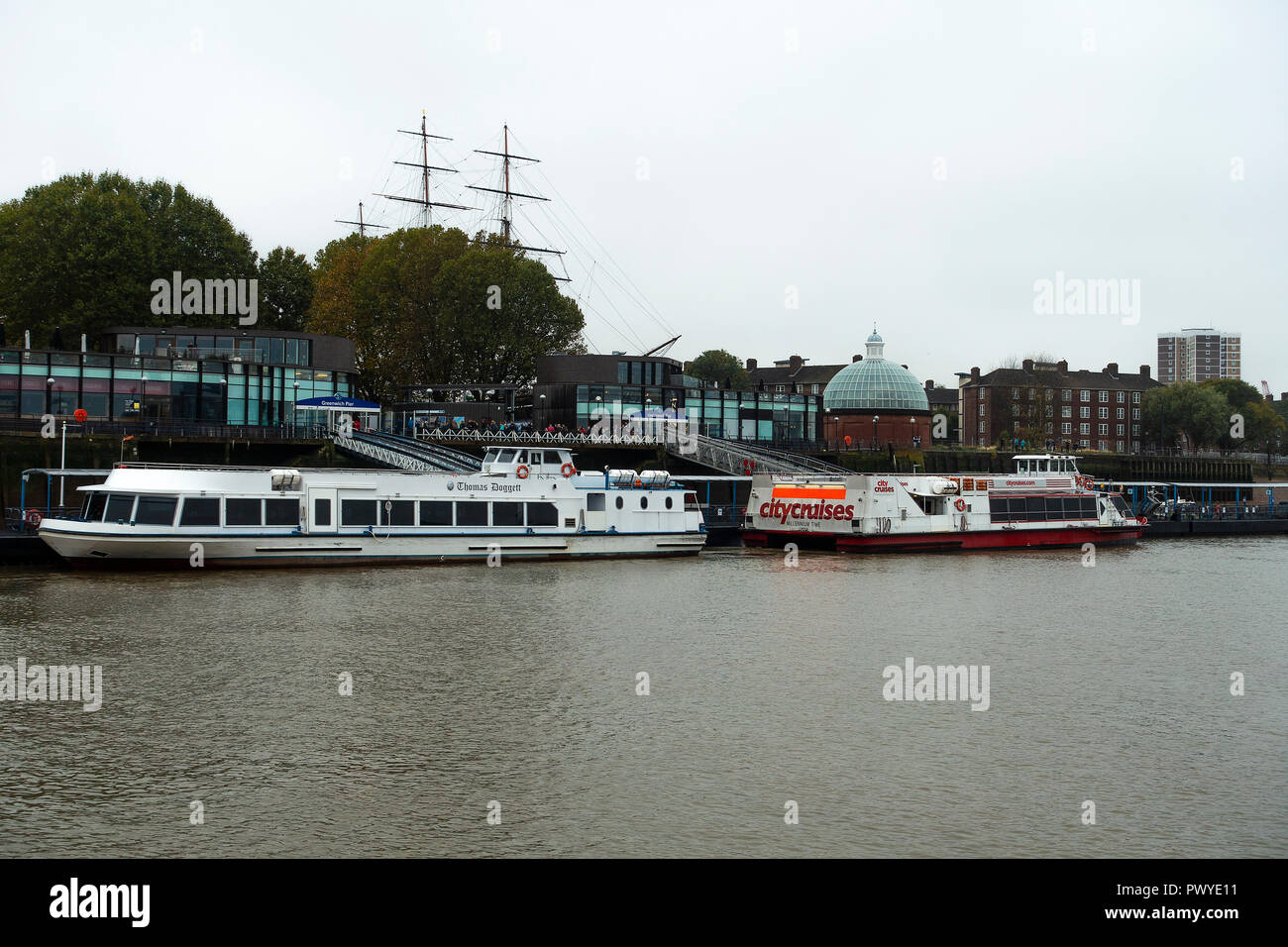 River Cruise Ferry Boats Moored at Greenwich Pier on the River Thames with Cutty Sark in Background Greenwich London England United Kingdom UK Stock Photo