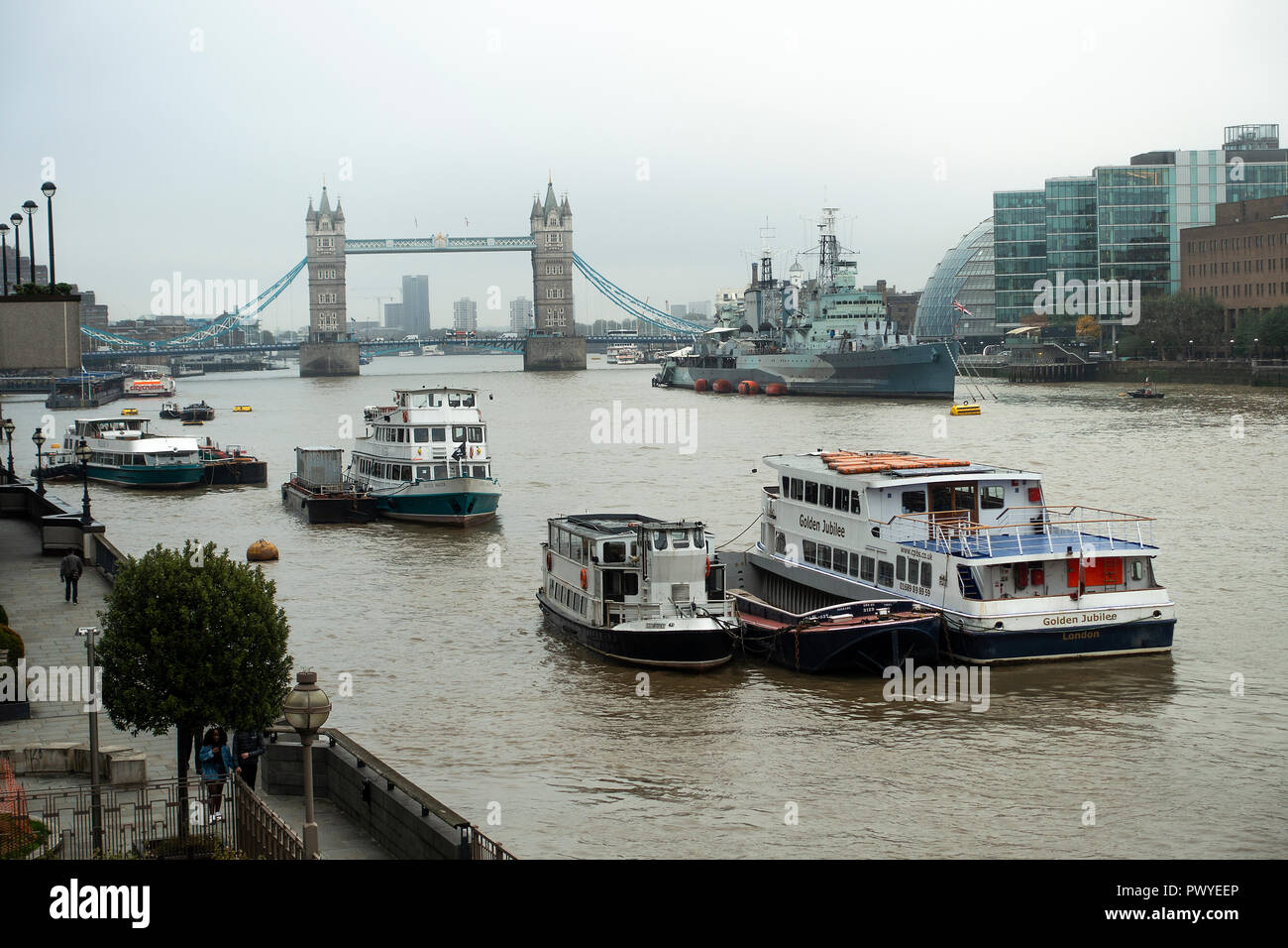 Tourist and Party Boats Moored in the River Thames with HMS Belfast and Tower Bridge in the Background London England United Kingdom UK Stock Photo
