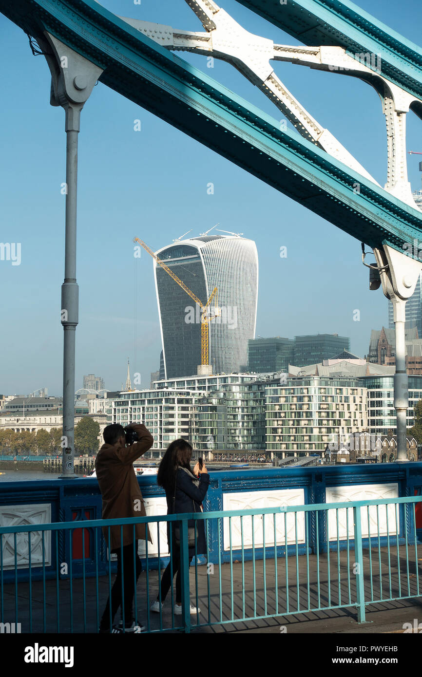 A Couple of Tourists Taking Pictures on Tower Bridge with The Walkie-Talkie Building 20 Fenchurch Street City of London England United Kingdom UK Stock Photo