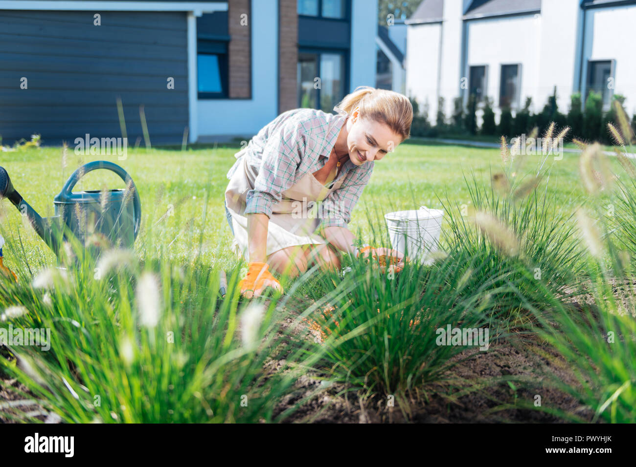 Woman looking at her garden bed while supporting sustainable environment Stock Photo