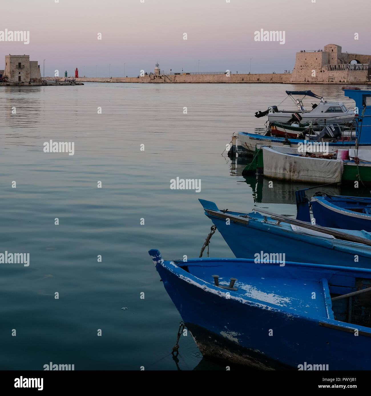 The picturesque fishing port at Trani, historic medieval town in Puglia, southern Italy. Colourful fishing boats in the foreground. Stock Photo