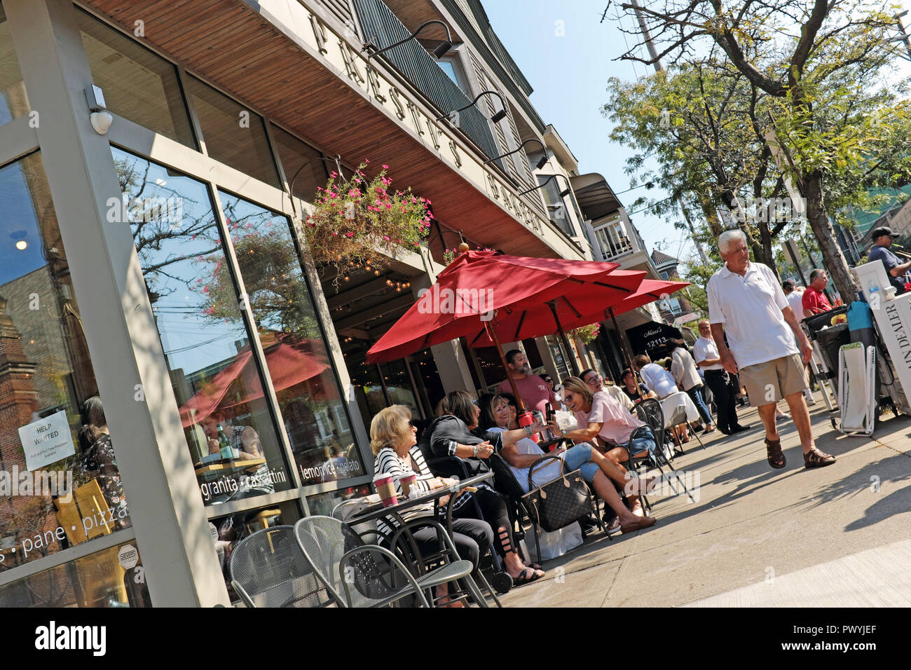 Cleveland residents enjoy the warm October weather at outdoor tables in front of Prestis in the Little Italy neighborhood of Cleveland, Ohio, USA. Stock Photo