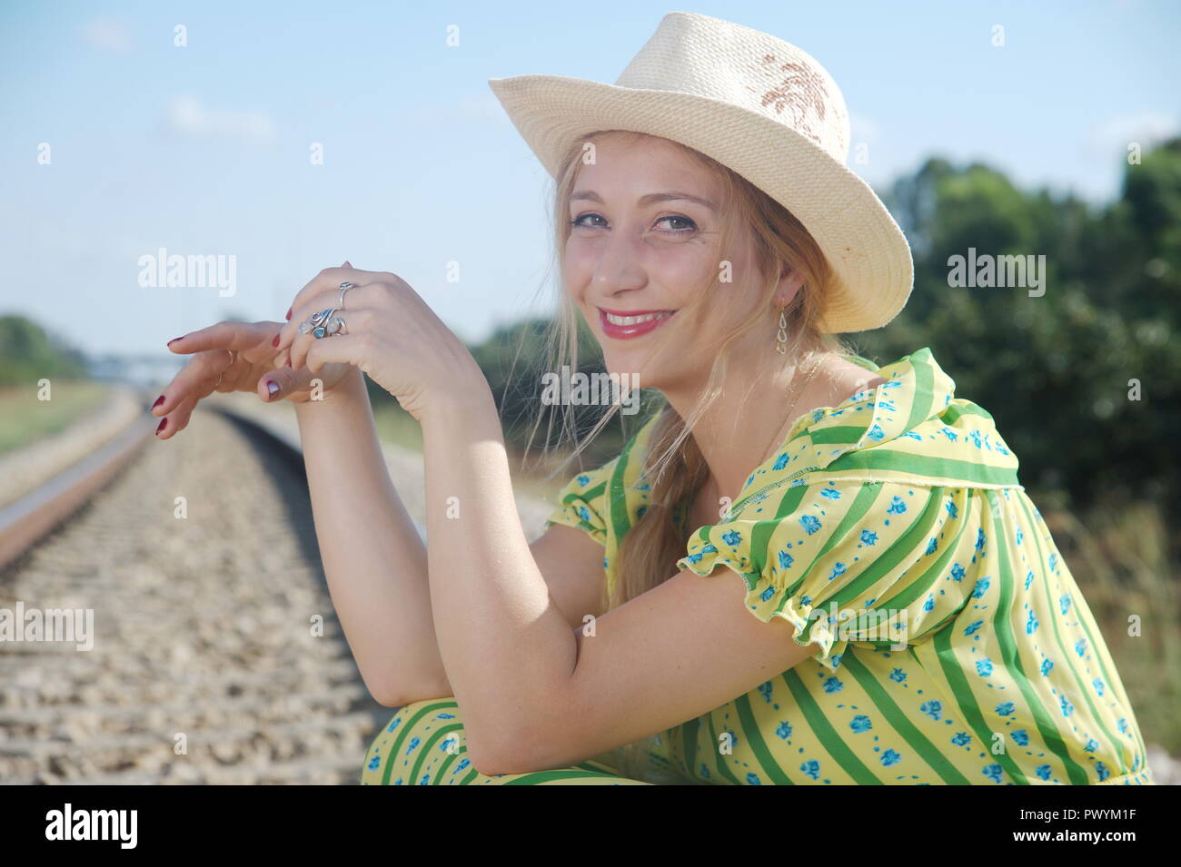 an amazing young blonde lady wait to locomotive, try stop train Stock Photo