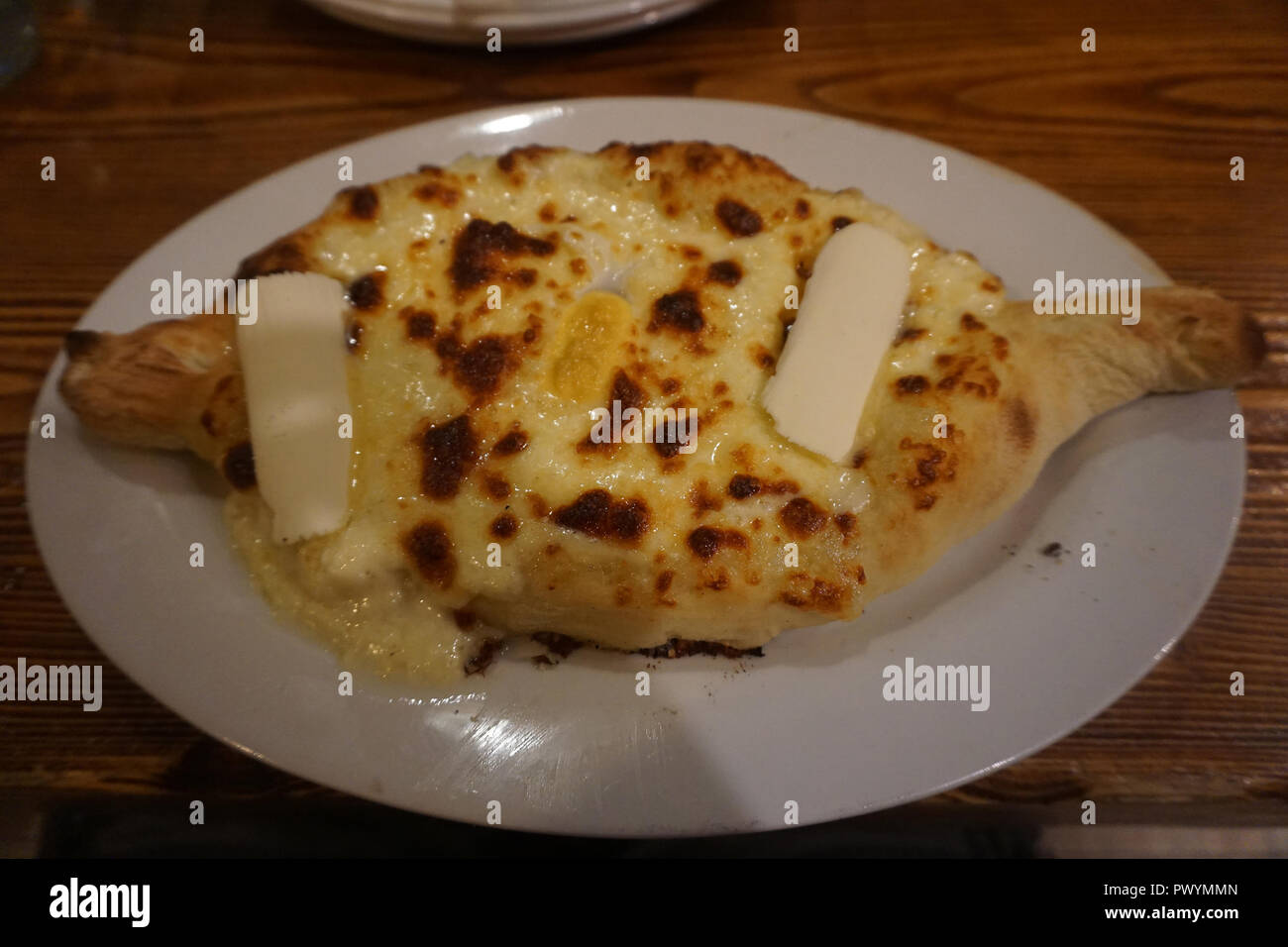 Georgian Traditional Khachapuri Ajaruli with Egg and Butter on a Plate Stock Photo