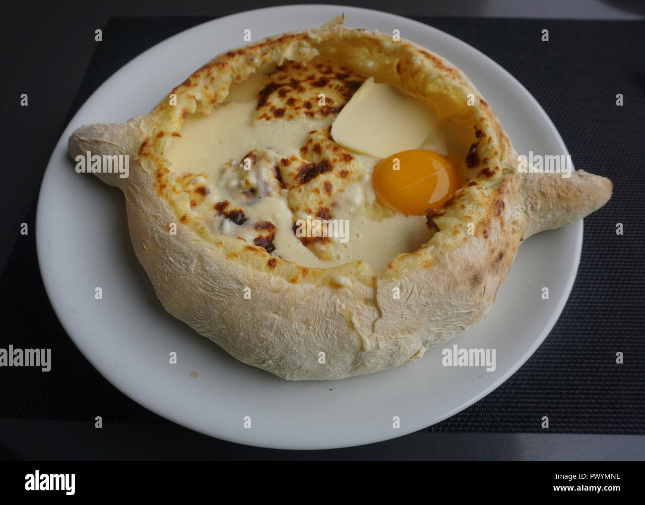 Georgian Khachapuri Ajaruli Served with Butter and Egg on a Plate Stock Photo