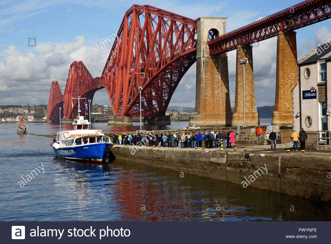 Tourists queueing at the Forth Bridge to join the Forth Belle Boat tour of the Forth Estuary and islands at South Queensferry, Scotland Stock Photo