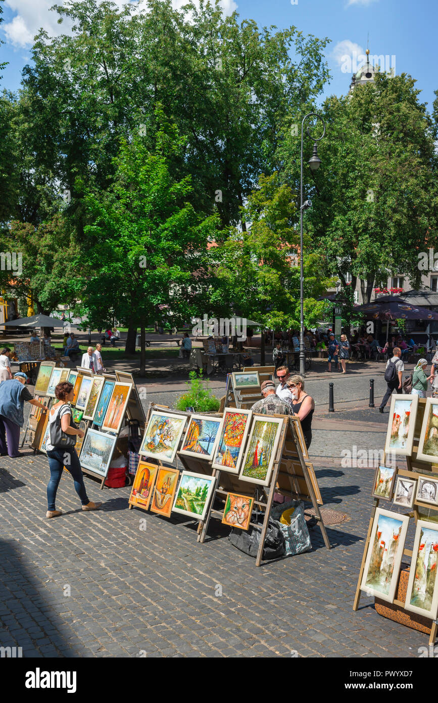 Paintings sale street, people in Vilnius Old Town look at a display of local artists' work for sale, Lithuania. Stock Photo