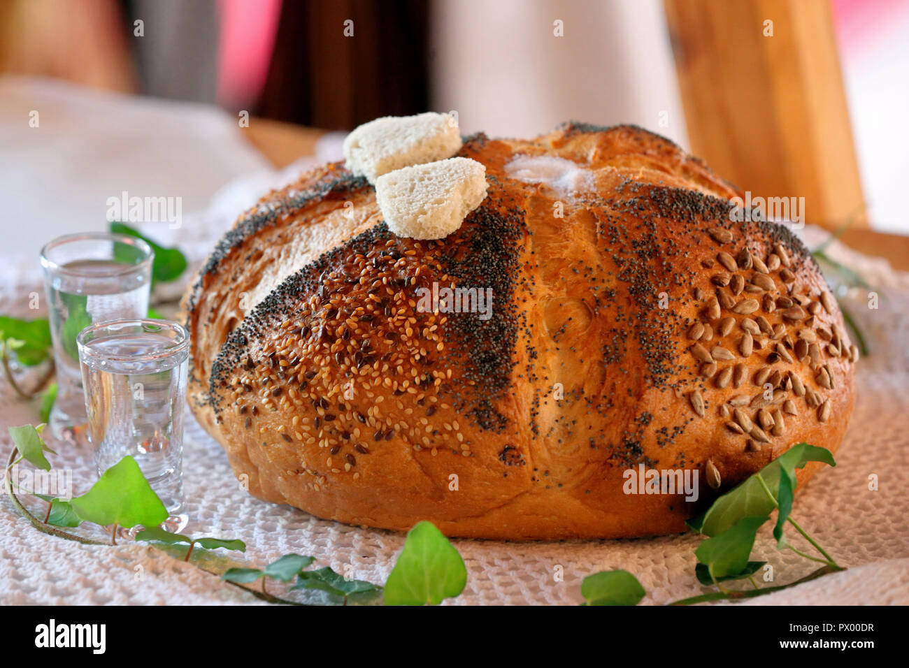 Round bread and vodka, a traditional greeting of a bride and groom on wedding reception Stock Photo