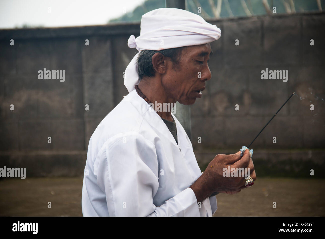 PEMUTERAN, BALI - JANUARY 2018: A hindu priest performing offerings in a temple in Pemuteran in Bali, Indonesia Stock Photo