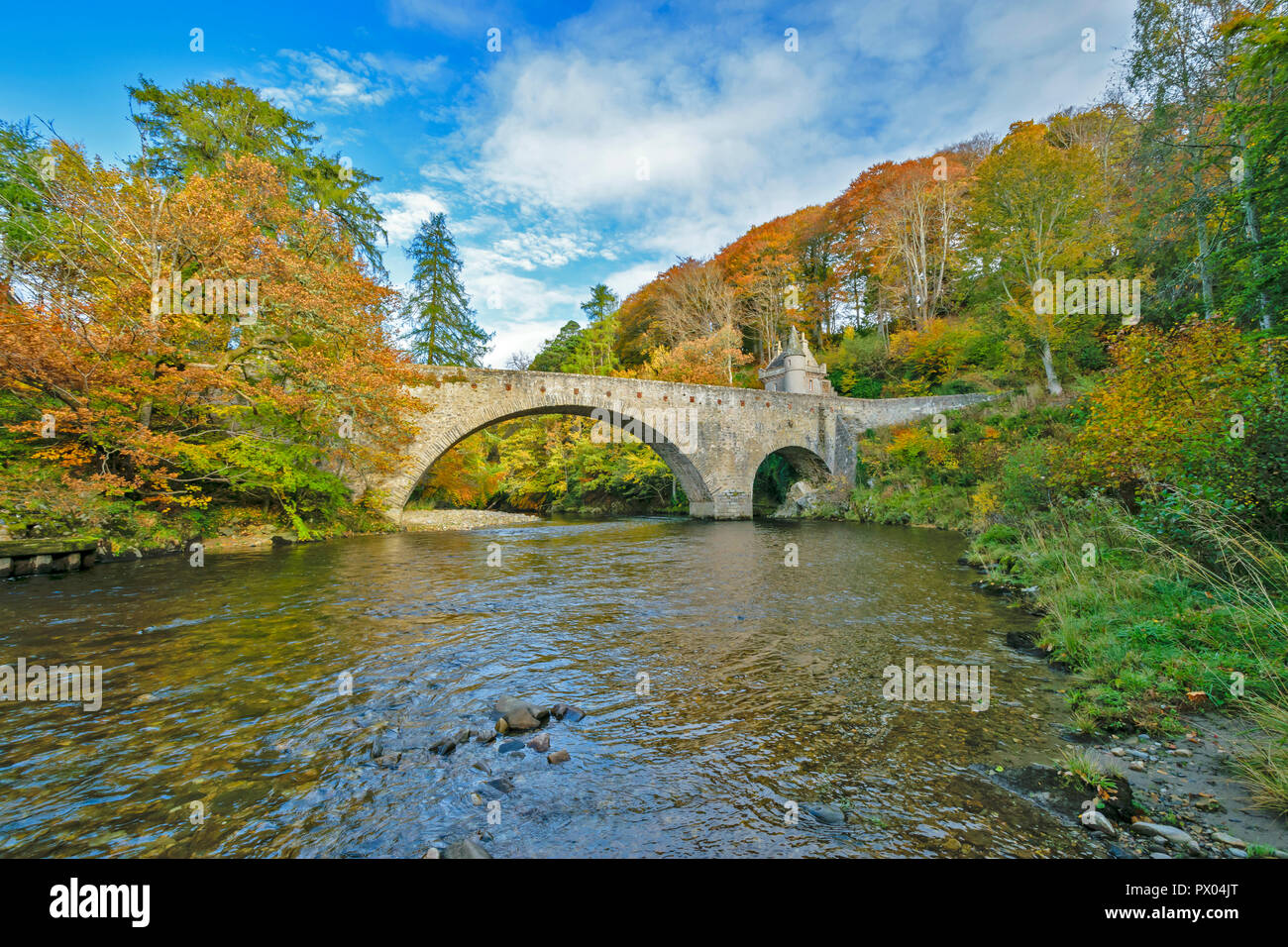 OLD BRIDGE OF AVON BALLINDALLOCH CASTLE GRAMPIAN SCOTLAND THE BRIDGE AND BARONIAL GATEHOUSE AND REFLECTED AUTUMNAL COLOURS IN THE RIVER Stock Photo