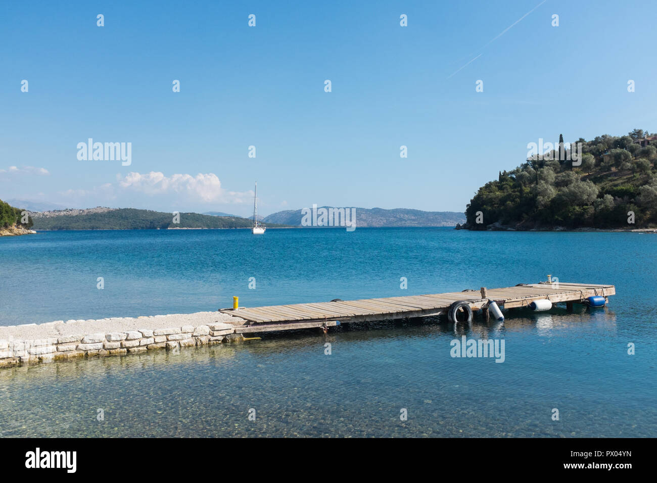Pontton for motor boats in the harbour at Agios Stefanos in north east Corfu with Albania in the background Stock Photo