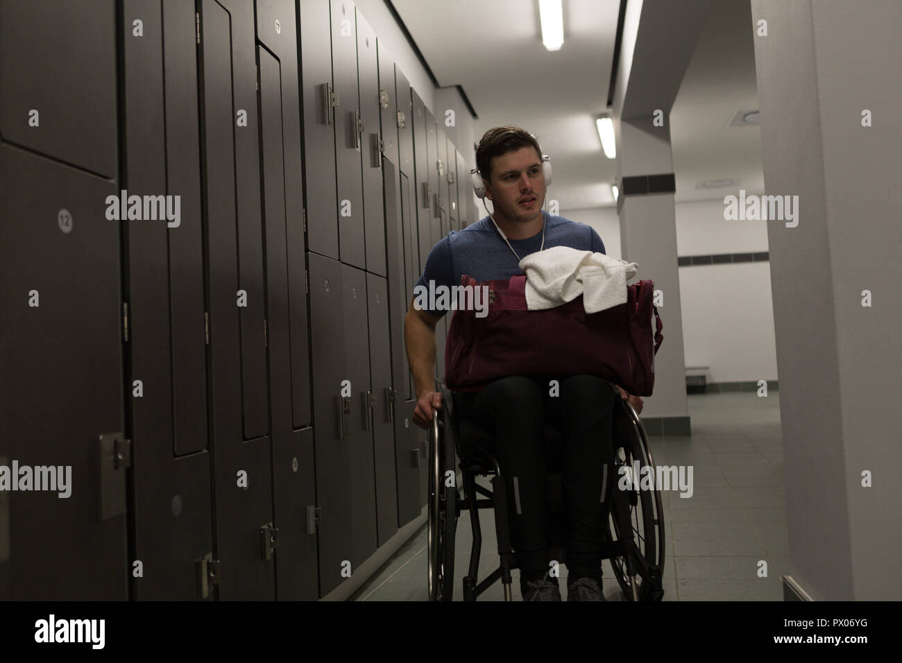 Disabled man with his bag in locker room Stock Photo