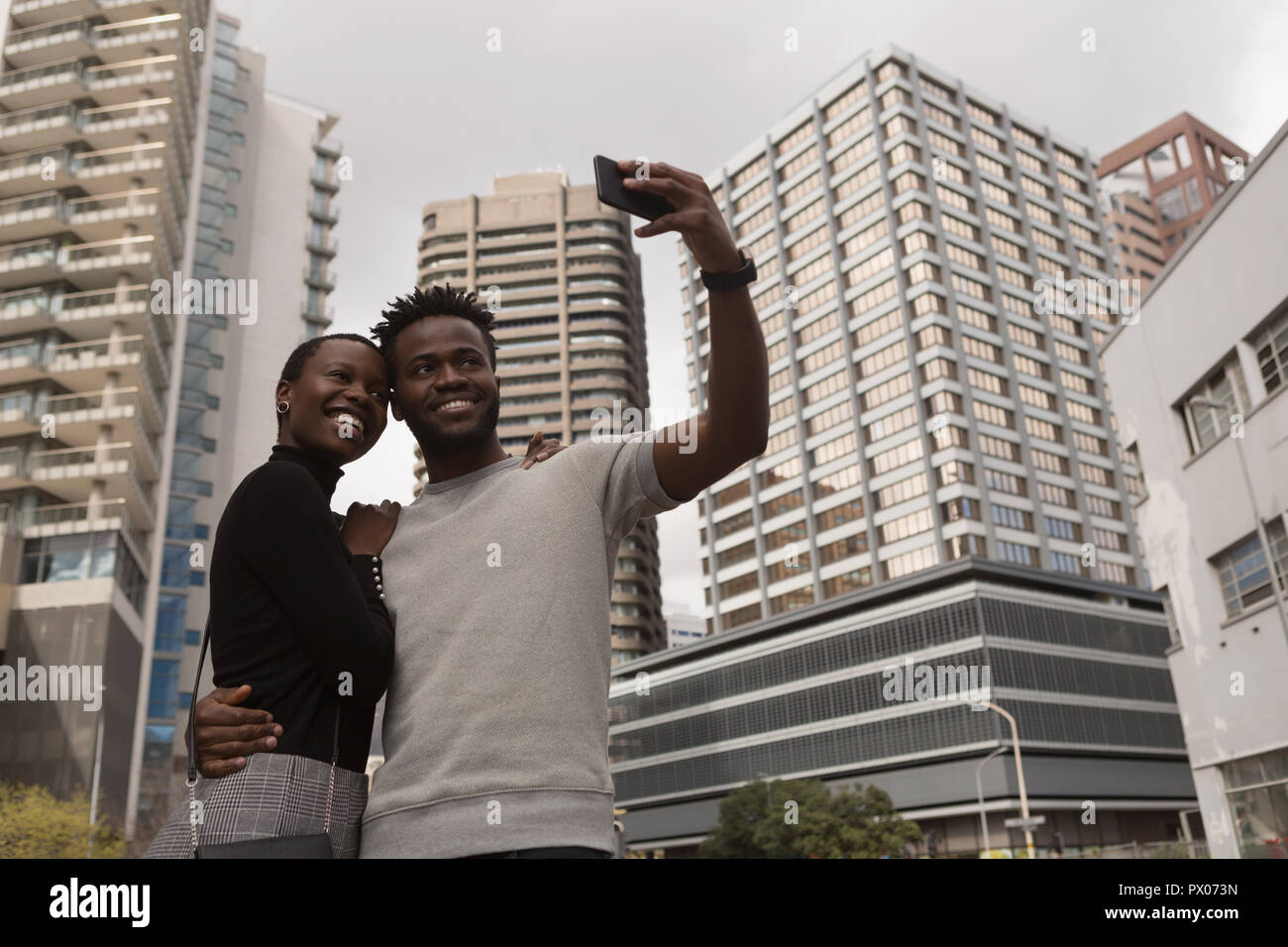 Couple taking selfie on city street Stock Photo