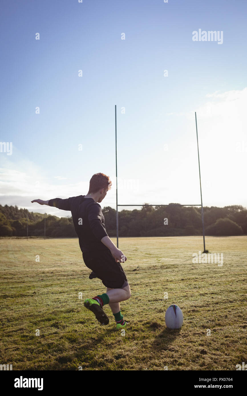Rugby player kicking rugby ball in the field Stock Photo Alamy