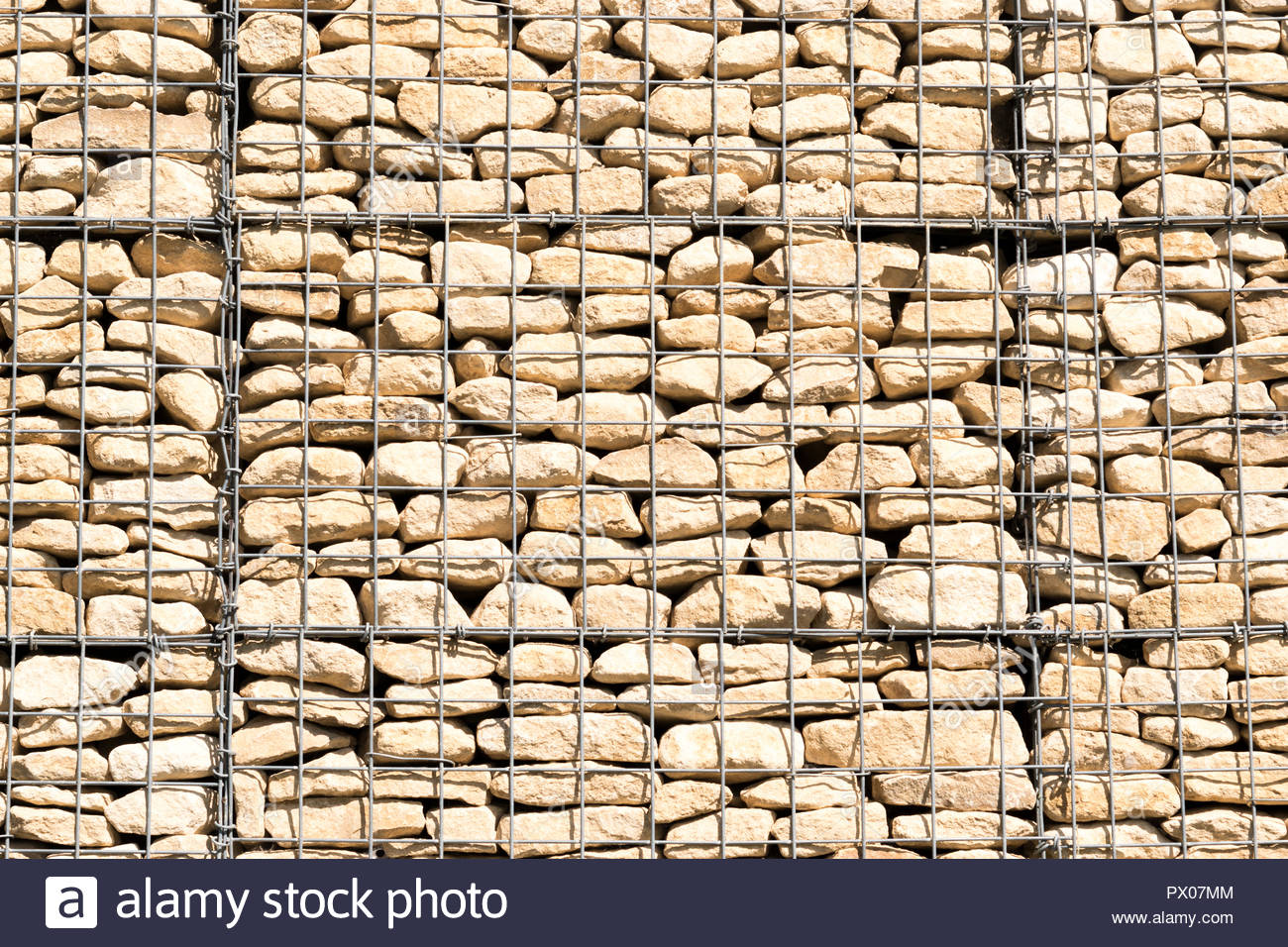 A retaining wall constructed from gabions, or wire mesh cages filled with rocks and concrete; a
