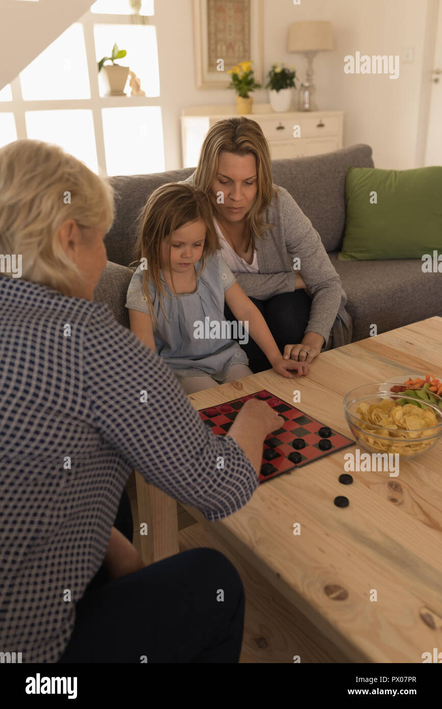 Multi-generation family playing game in living room Stock Photo