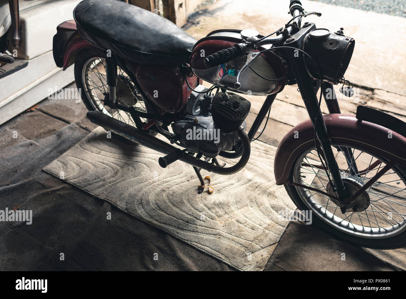Motorbike standing in garage Stock Photo Alamy