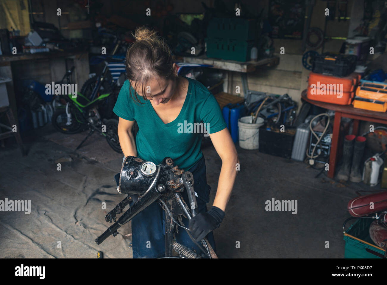 Female Mechanic Repairing Motorbike In Garage Stock Photo