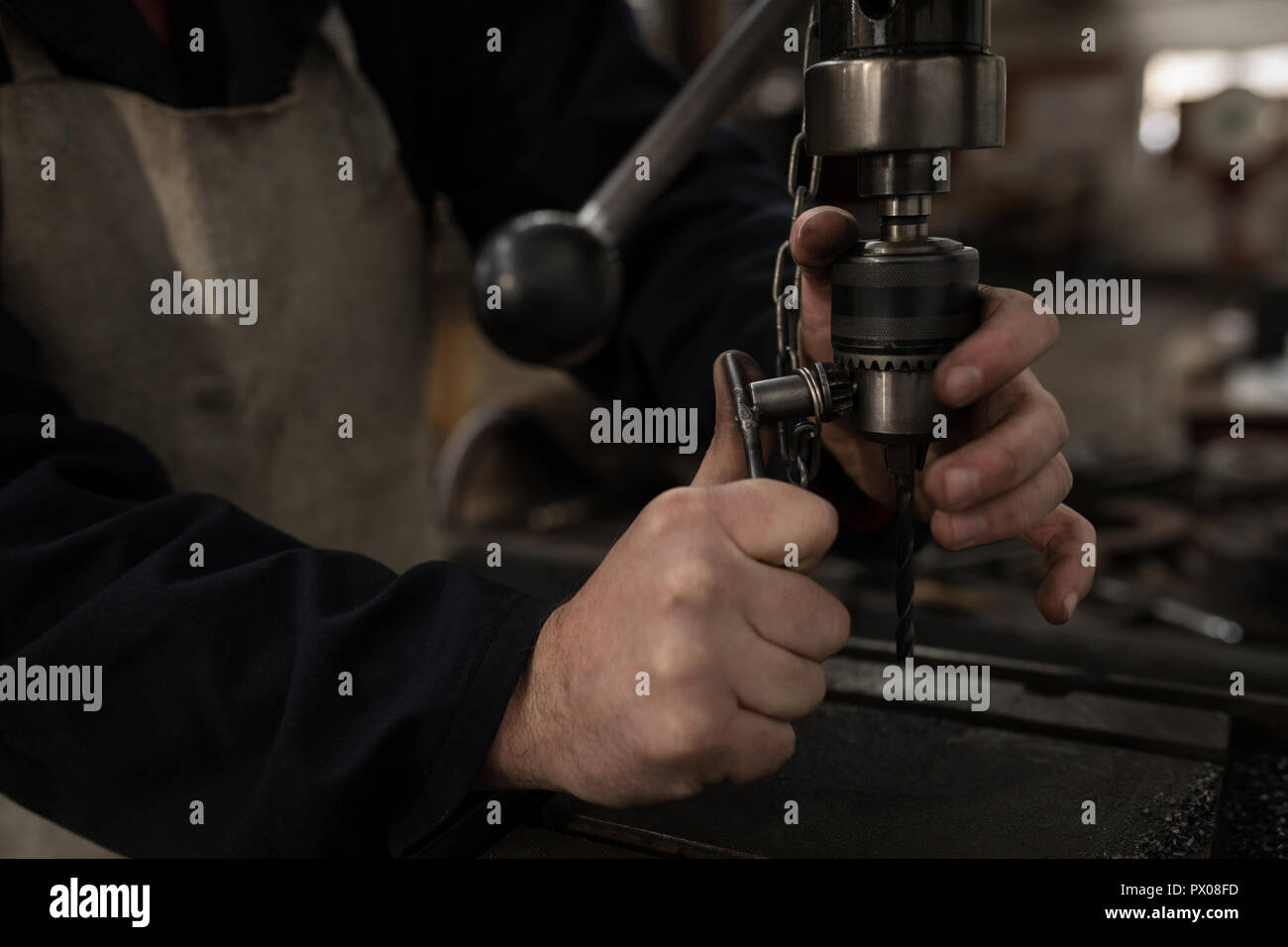 Blacksmith using press drill in workshop Stock Photo