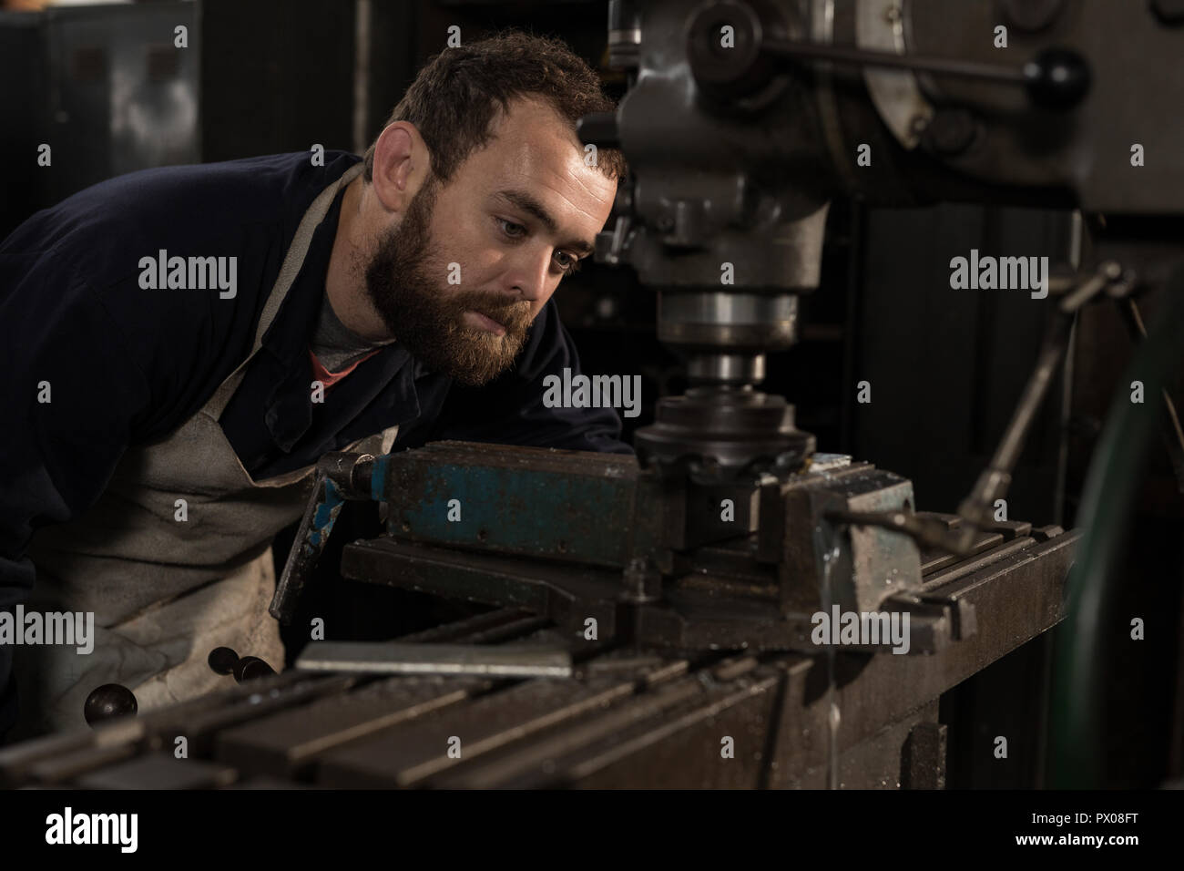 Blacksmith using press drill in workshop Stock Photo