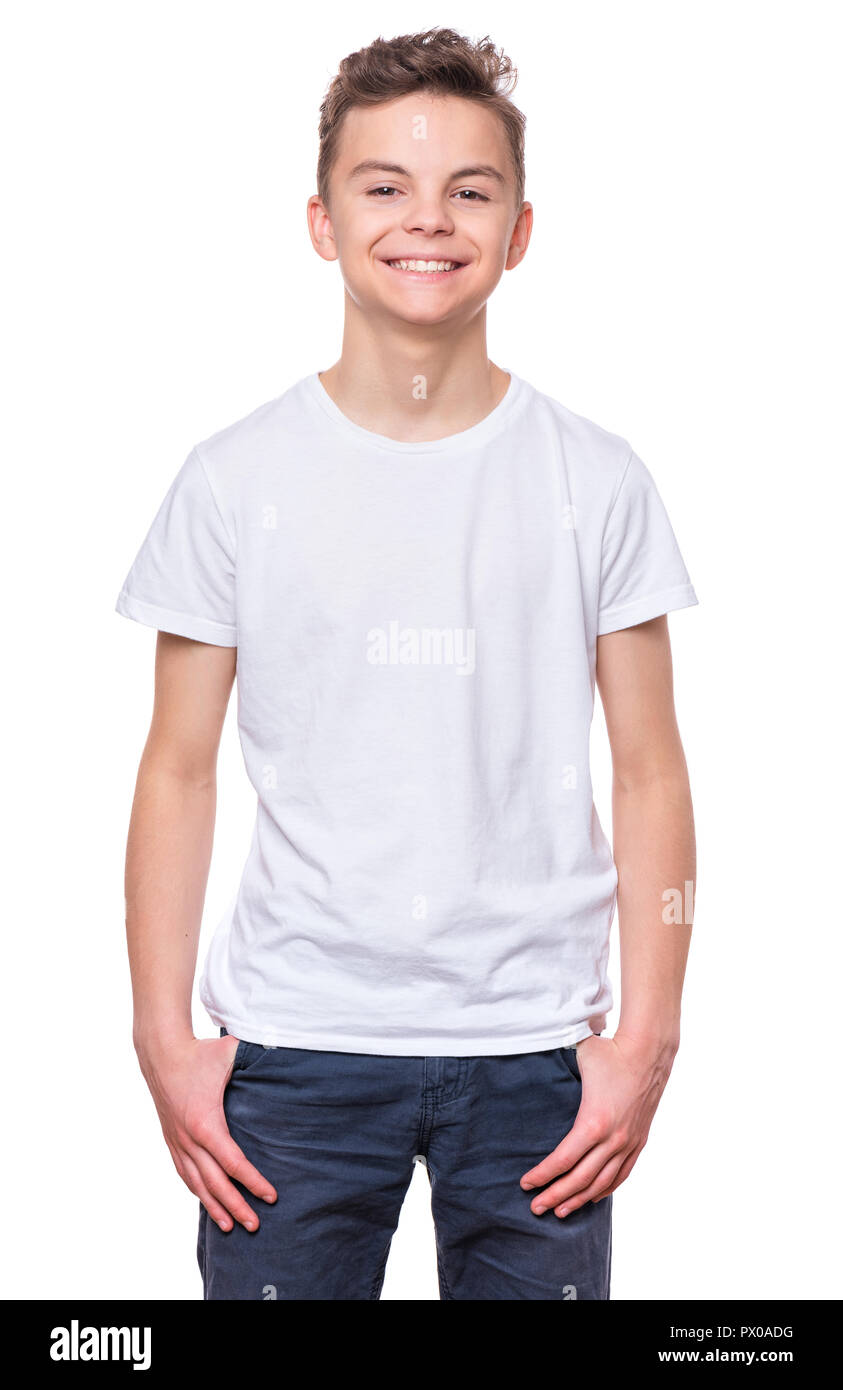 White t-shirt on teen boy. Handsome caucasian smiling child, isolated on a white background. Concept of childhood and fashion or advertisement design. Stock Photo