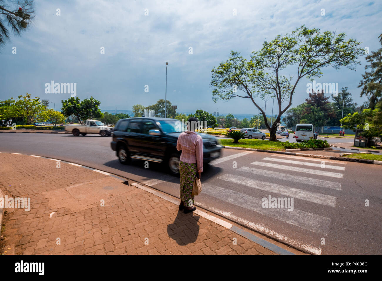 Kigali, Rwanda - September 20, 2018: A pedestrian waiting as a car passes at a crossing near the city centre Stock Photo