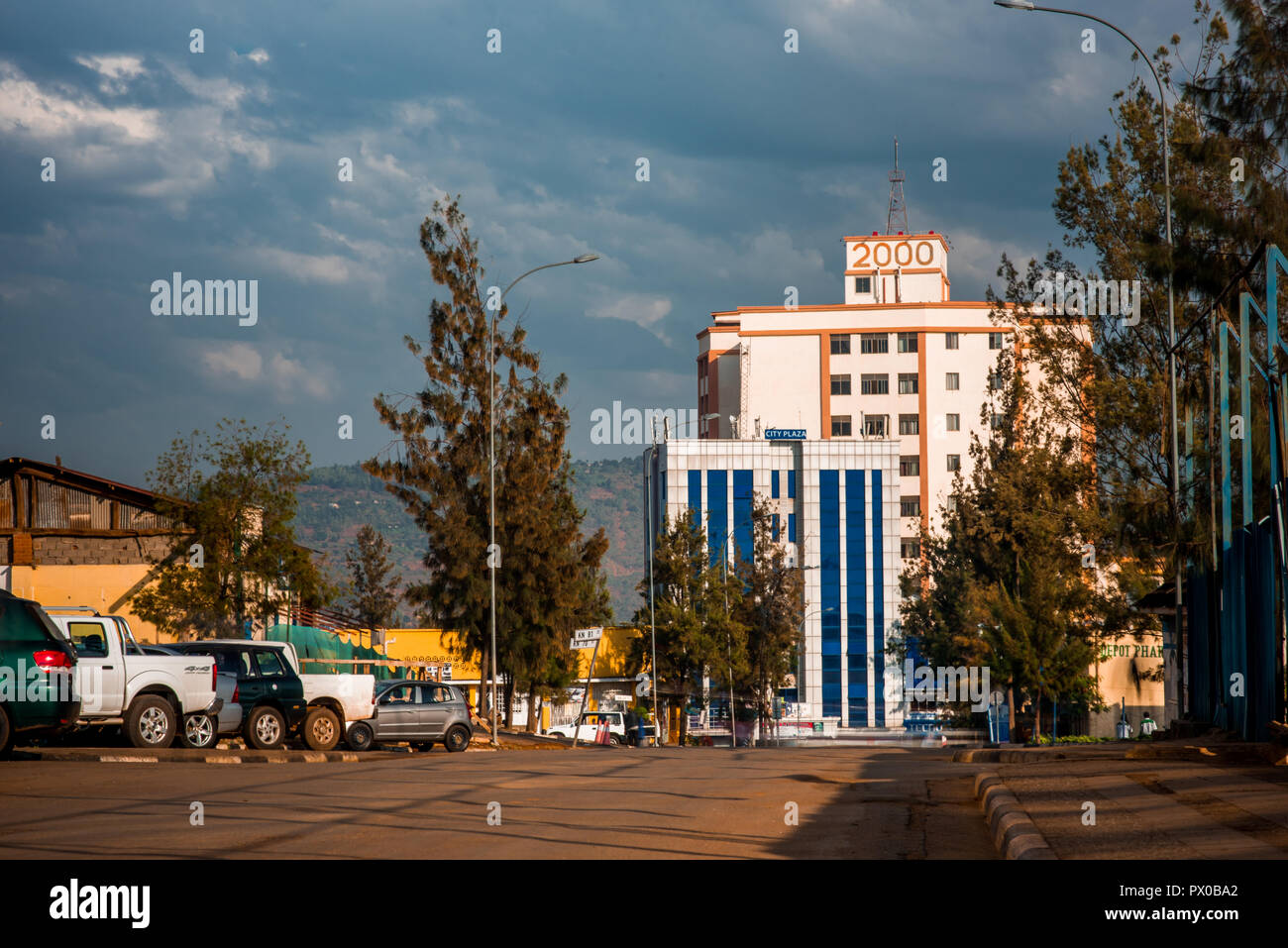 Kigali, Rwanda - September 21, 2018: House 2000, known locally as T 2000, lit up by the sun against dark clouds, viewed from street level Stock Photo