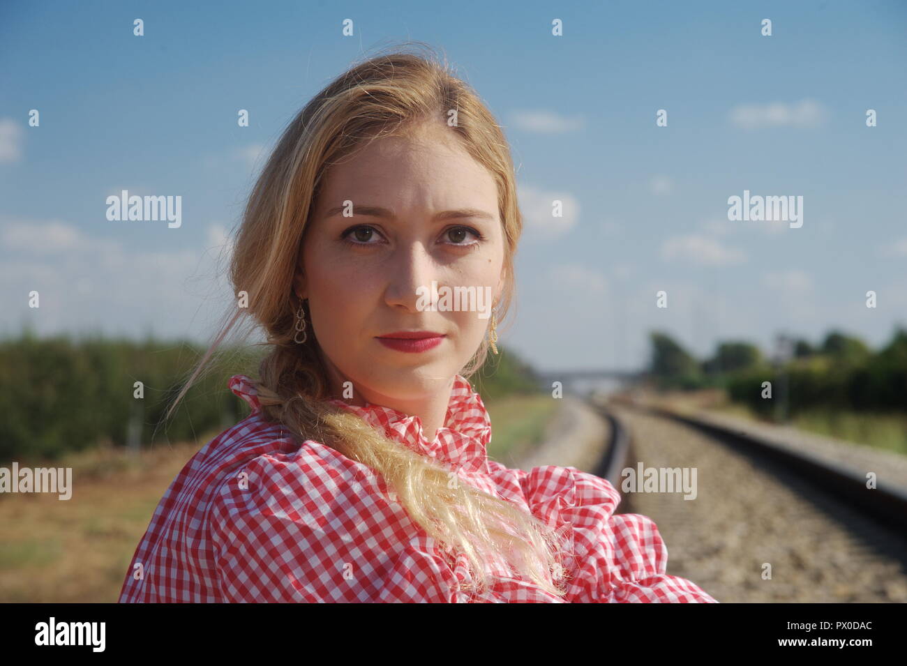 an amazing blonde woman ask for hitchhiking from loco, locomotive Stock Photo