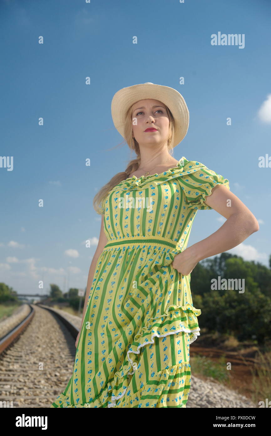 an amazing blonde woman ask for hitchhiking from loco, locomotive Stock Photo