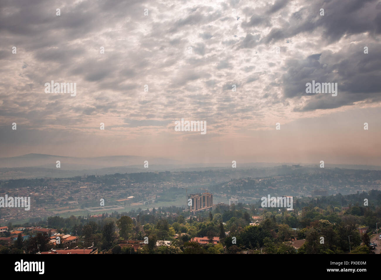 Sunlight breaks through the clouds over the hills of Rwanda that stretch into the distace Stock Photo