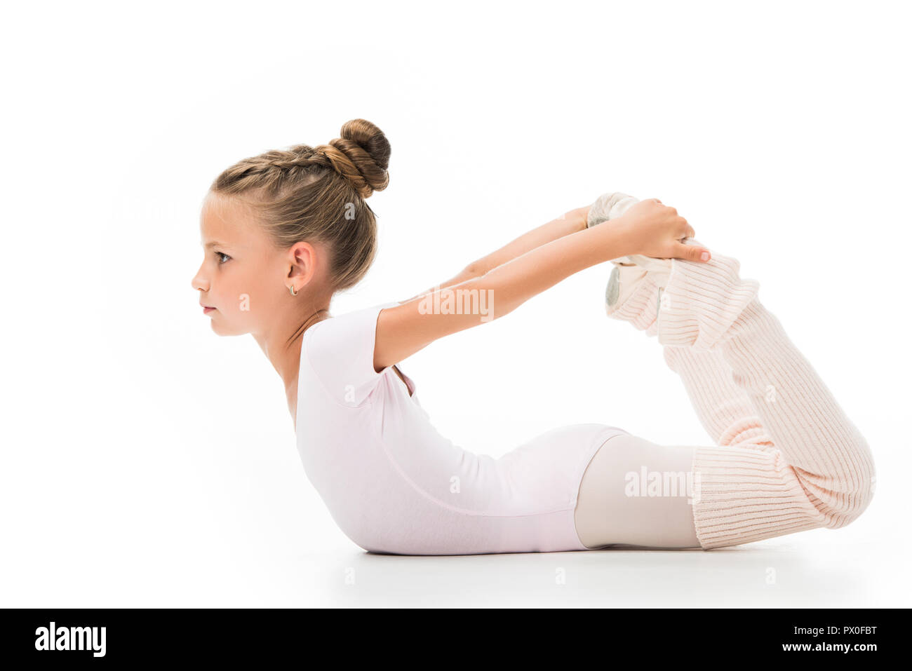 side view of focused little ballerina stretching isolated on white background Stock Photo