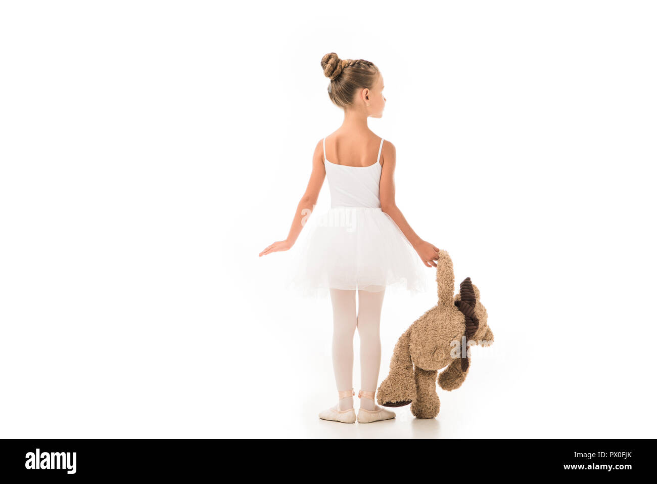 rear view of little ballerina in tutu practicing with teddy bear ...