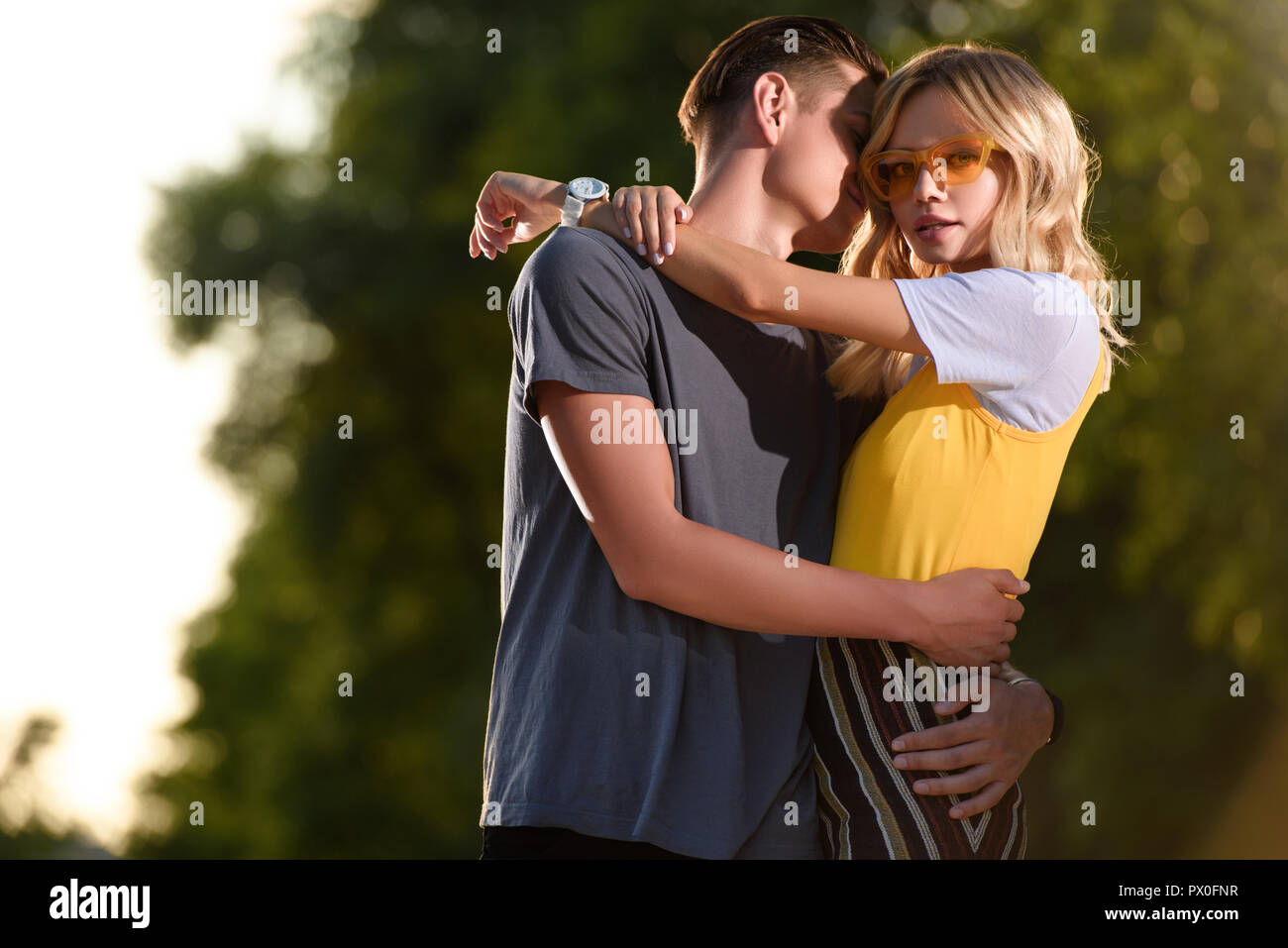 boyfriend hugging girlfriend in park in evening Stock Photo