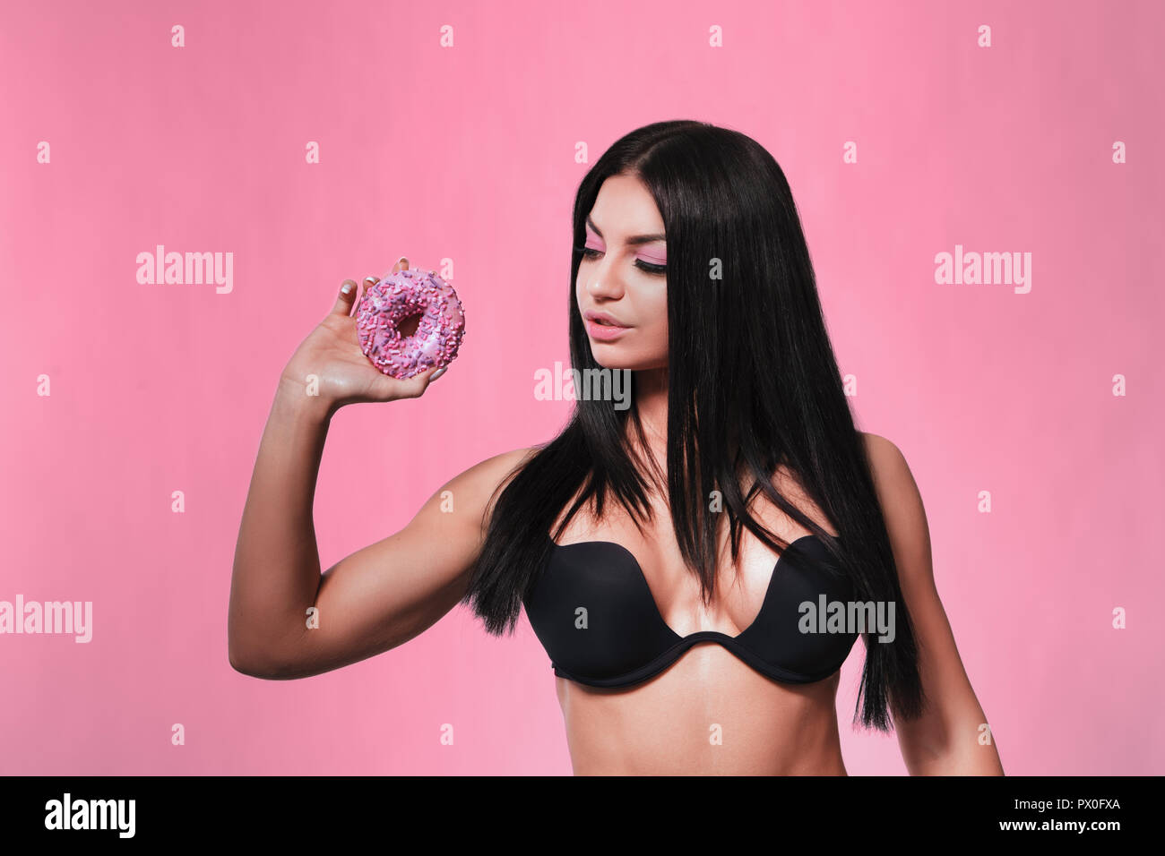 Beauty fashion model girl taking colorful donuts Stock Photo