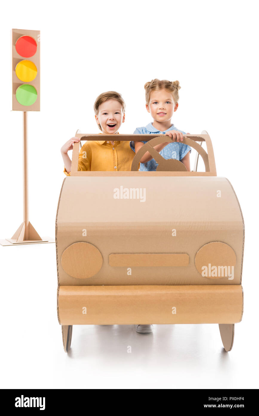 excited adorable children driving cardboard car with traffic lights on background, on white Stock Photo