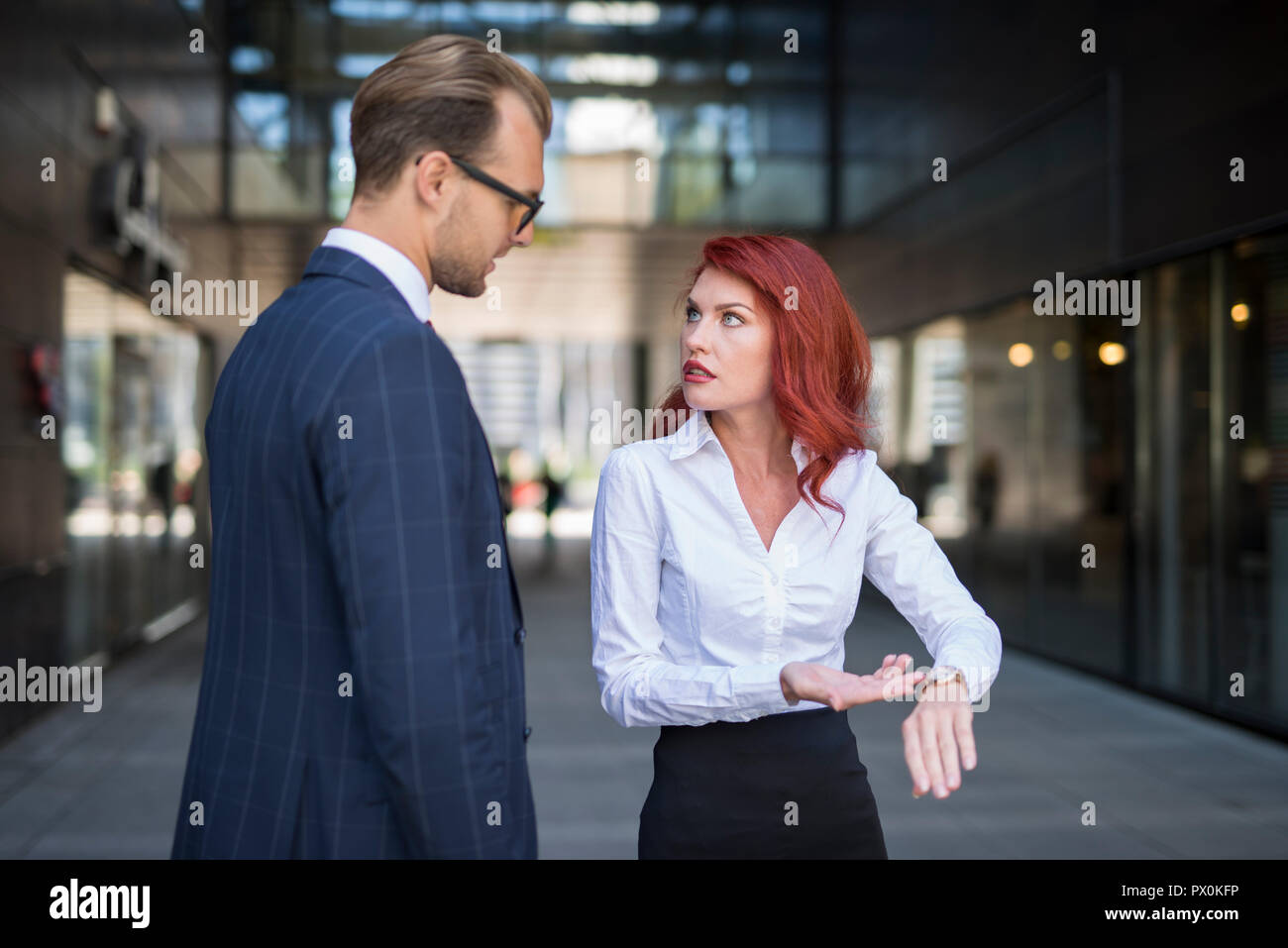 Woman scolding a colleague for being late Stock Photo