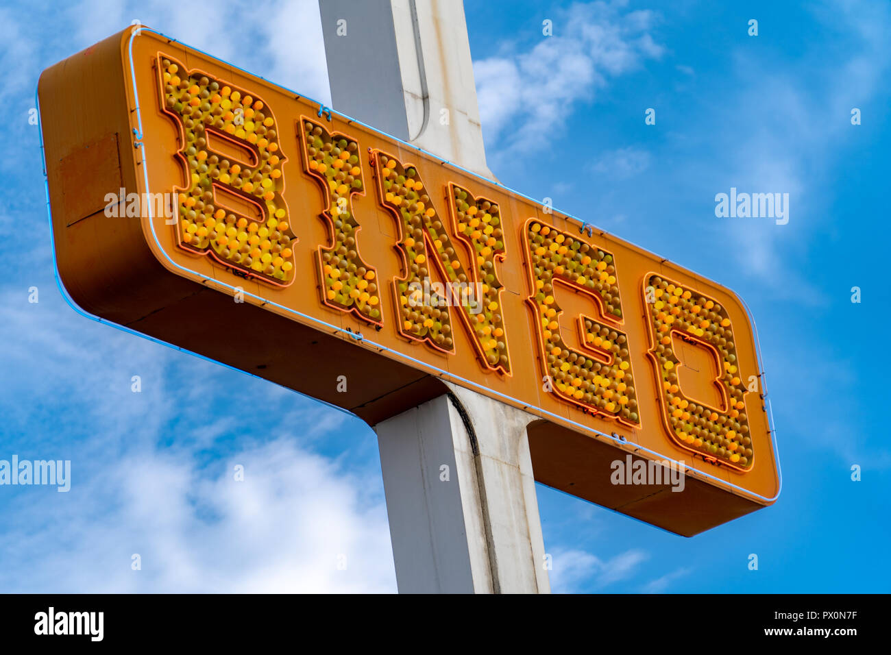 Generic BINGO neon sign in orange lights, unlit, in the daytime against a blue sky Stock Photo