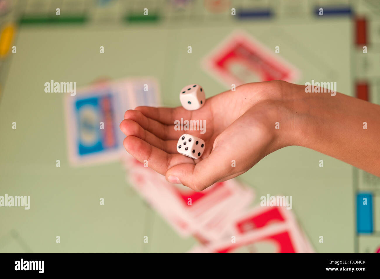 The hand throws game dice on the background of the playing field. man