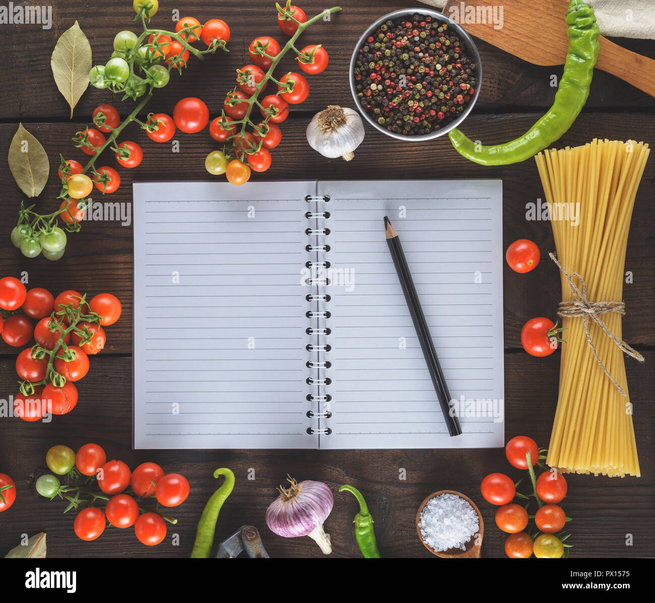 blank notebook with white sheets, raw long paste and ingredients for cooking, top view Stock Photo