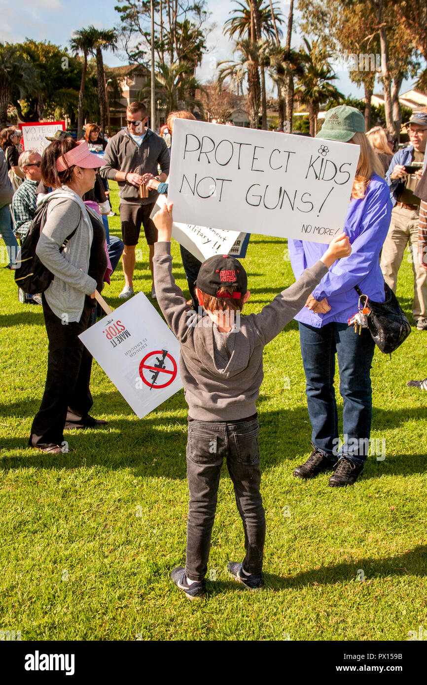 A boy carries a sign advocating gun control as protesters demonstrate in a Long Beach, CA, municipal park. Stock Photo